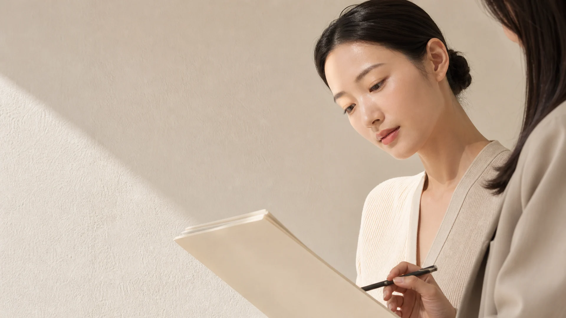 企画資料を見ながら打ち合わせをする二人の担当者のイメージ